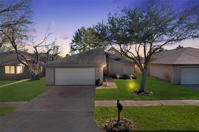 ranch-style home with a garage and a lawn