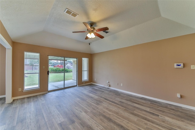 unfurnished room with a textured ceiling, ceiling fan, vaulted ceiling, and hardwood / wood-style flooring