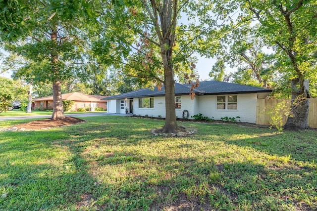 single story home featuring a front lawn and a garage