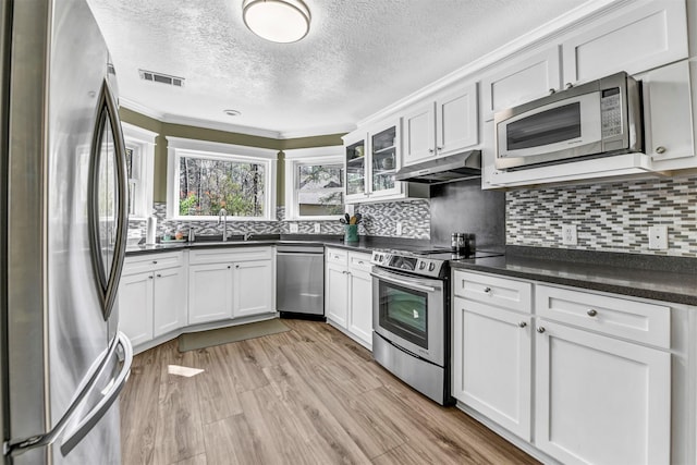 kitchen with sink, white cabinetry, ornamental molding, and appliances with stainless steel finishes