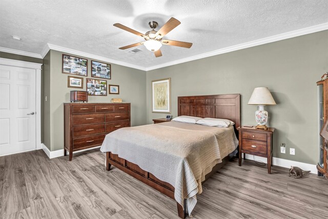 bedroom featuring crown molding, a textured ceiling, a closet, light hardwood / wood-style flooring, and ceiling fan