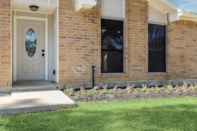 entrance to property with a lawn