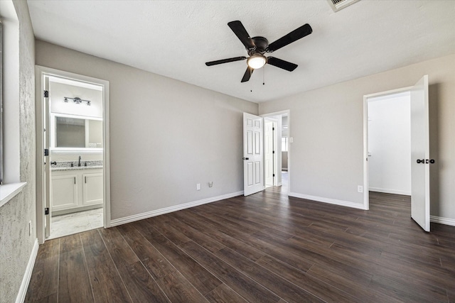 unfurnished bedroom featuring ensuite bath, ceiling fan, dark hardwood / wood-style flooring, and sink