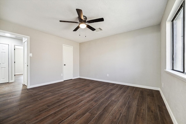 spare room featuring ceiling fan and dark wood-type flooring