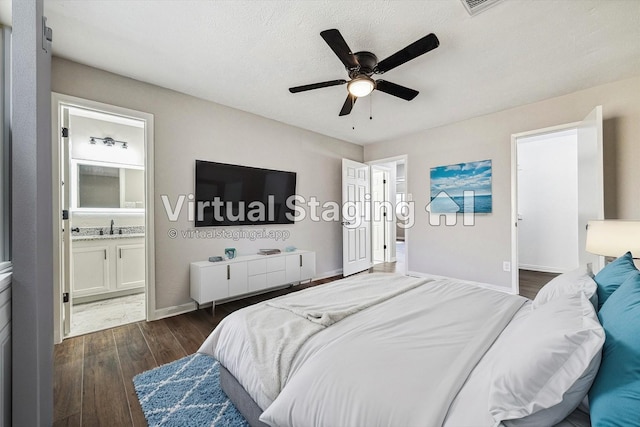 bedroom with ensuite bathroom, a textured ceiling, ceiling fan, dark wood-type flooring, and sink