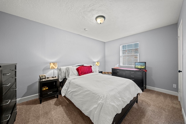 bedroom with a textured ceiling and dark colored carpet