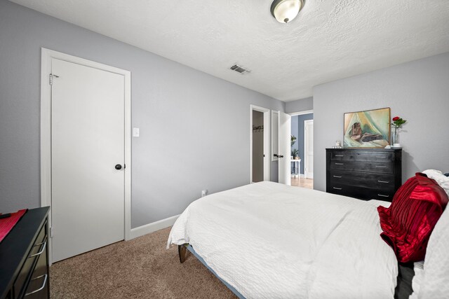 carpeted bedroom with a textured ceiling