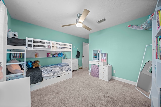 carpeted bedroom with a textured ceiling and ceiling fan