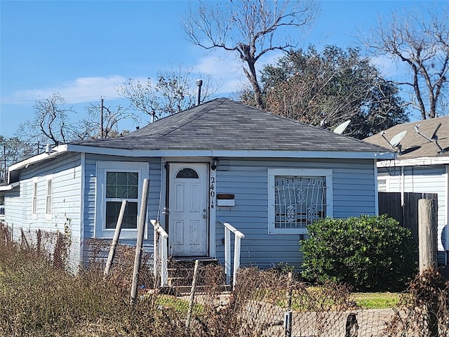 view of front of property featuring a shingled roof and fence