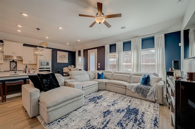 living room featuring ceiling fan and light hardwood / wood-style floors