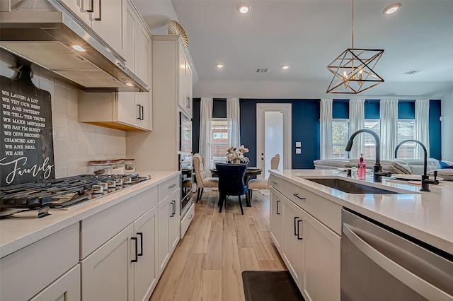 kitchen featuring pendant lighting, decorative backsplash, white cabinetry, and appliances with stainless steel finishes