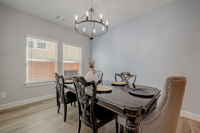 dining space featuring light hardwood / wood-style floors and an inviting chandelier