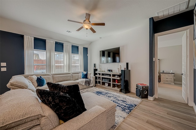 living room featuring ceiling fan, light hardwood / wood-style floors, and lofted ceiling