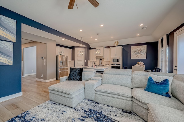 living room with ceiling fan and light wood-type flooring