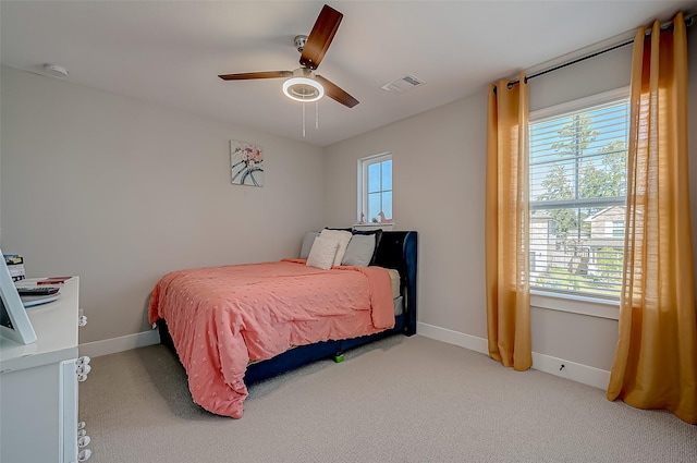 bedroom with light carpet, multiple windows, and ceiling fan