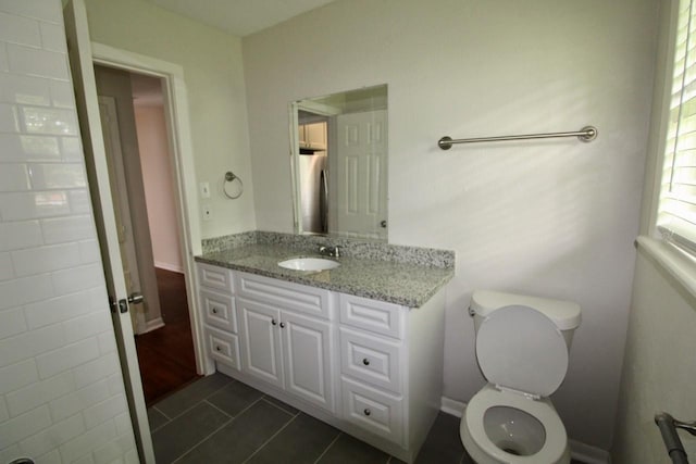 bathroom featuring toilet, vanity, and tile patterned floors