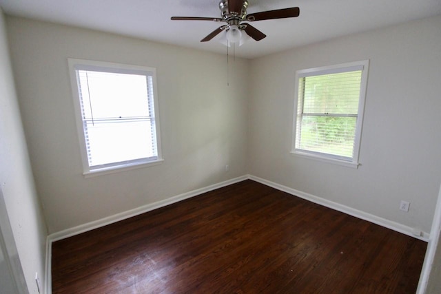 spare room with ceiling fan, dark wood-type flooring, and a healthy amount of sunlight