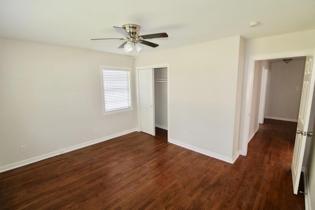 unfurnished bedroom featuring ceiling fan, dark hardwood / wood-style flooring, and a closet