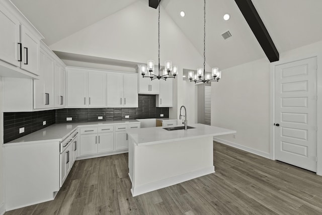 16710 Yaklin Meadow Ct, Humble, TX 77346 - kitchen with a chandelier, high vaulted ceiling, a center island with sink, decorative backsplash, and white cabinetry