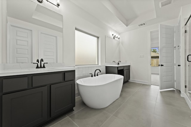 16710 Yaklin Meadow Ct, Humble, TX 77346 - full bathroom featuring two vanities, a stall shower, a freestanding tub, tile patterned floors, and a tray ceiling