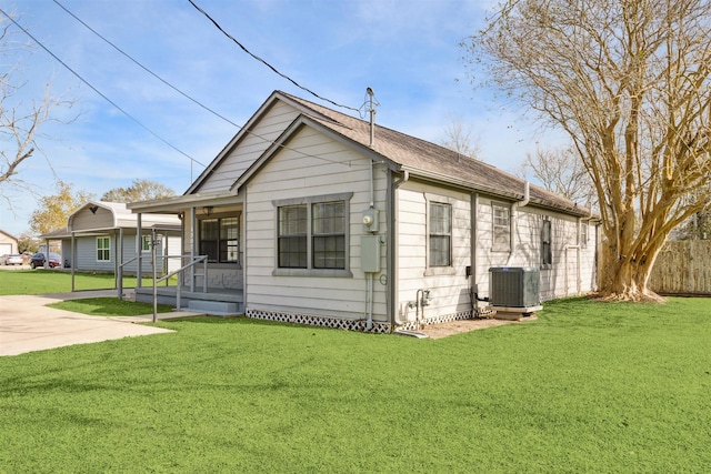 exterior space featuring central AC unit and a yard