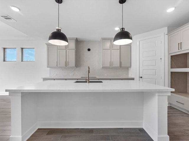3248 Stingray Cove Dr, Katy, TX 77493 - kitchen with a sink, gray cabinets, visible vents, dark wood-style flooring, and a large island