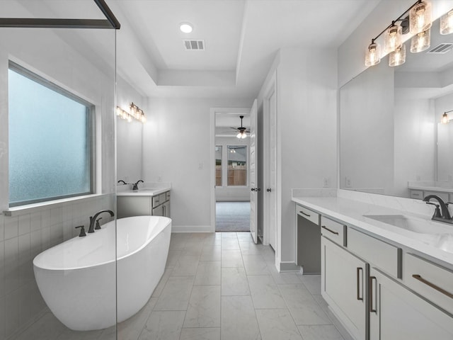 3248 Stingray Cove Dr, Katy, TX 77493 - full bath with a freestanding tub, two vanities, marble finish floors, ceiling fan, and a tray ceiling