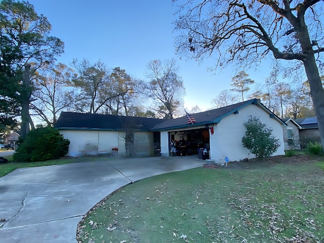 single story home with a garage and a front lawn