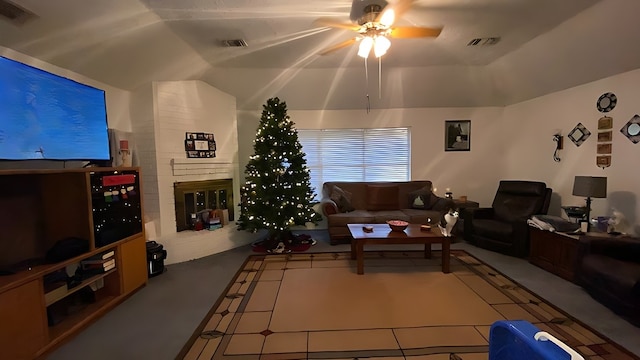 living room featuring ceiling fan, a fireplace, and lofted ceiling