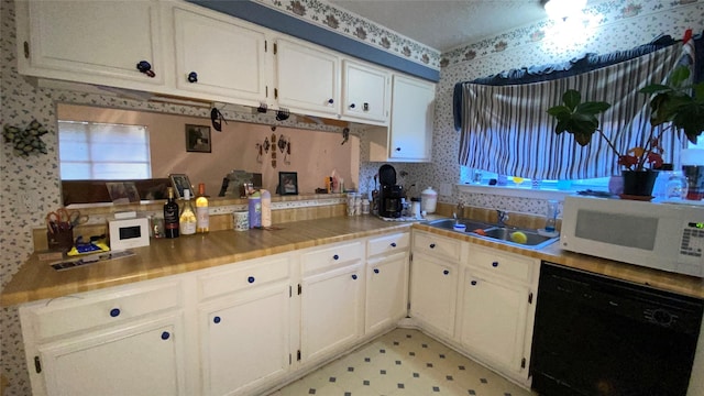 kitchen with dishwasher, white cabinets, and sink