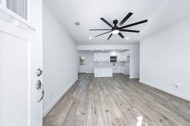 unfurnished living room featuring ceiling fan and light wood-type flooring