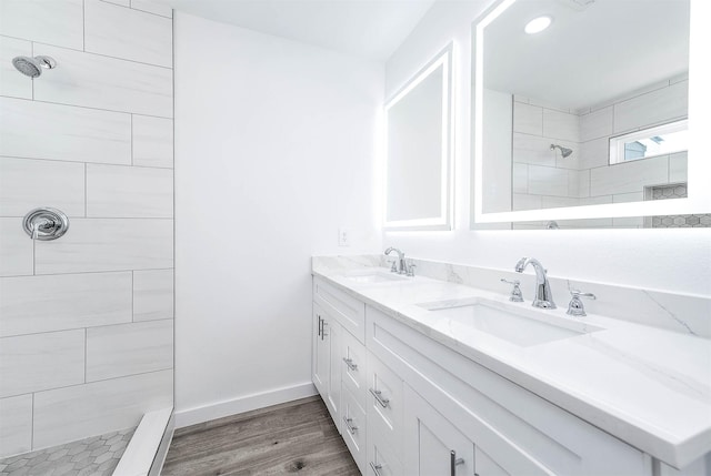 bathroom featuring tiled shower, hardwood / wood-style floors, and vanity