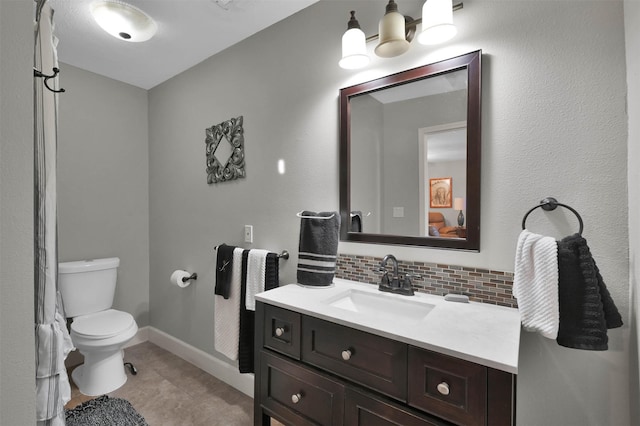 bathroom with vanity, tasteful backsplash, and toilet