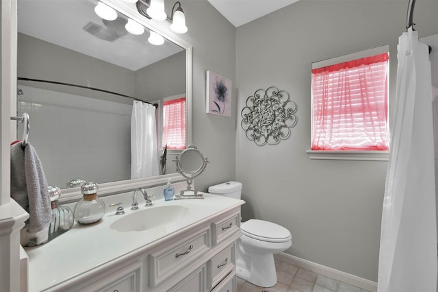 bathroom featuring tile patterned flooring, vanity, a healthy amount of sunlight, and toilet