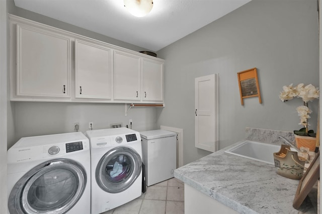 washroom with light tile patterned flooring, cabinets, separate washer and dryer, and sink