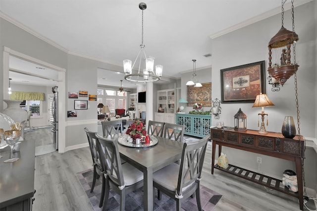 dining room with crown molding, a healthy amount of sunlight, and light wood-type flooring