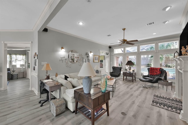 living room with ceiling fan, light wood-type flooring, and ornamental molding