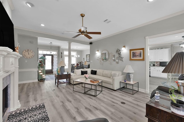 living room featuring ceiling fan, light wood-type flooring, and ornamental molding