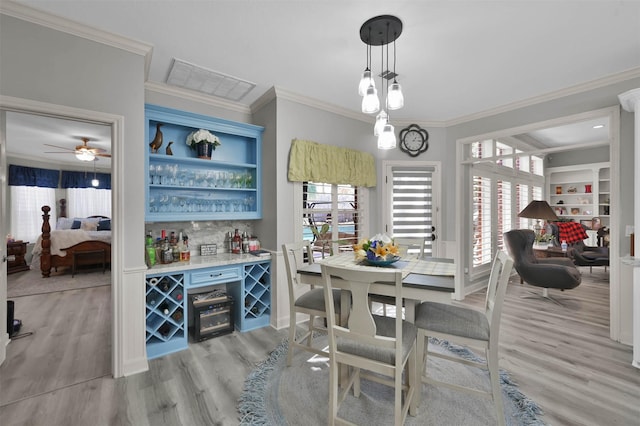 interior space featuring ceiling fan, light wood-type flooring, and ornamental molding