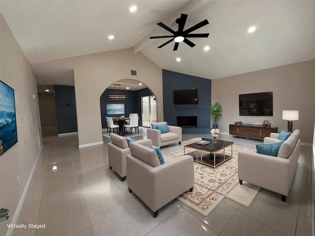 living room featuring lofted ceiling with beams, ceiling fan, light tile patterned flooring, and a fireplace