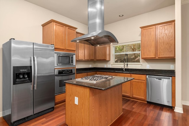 kitchen featuring dark stone counters, sink, a kitchen island, island exhaust hood, and stainless steel appliances