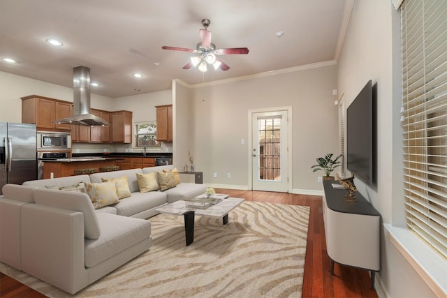 living room with hardwood / wood-style flooring, ceiling fan, and crown molding