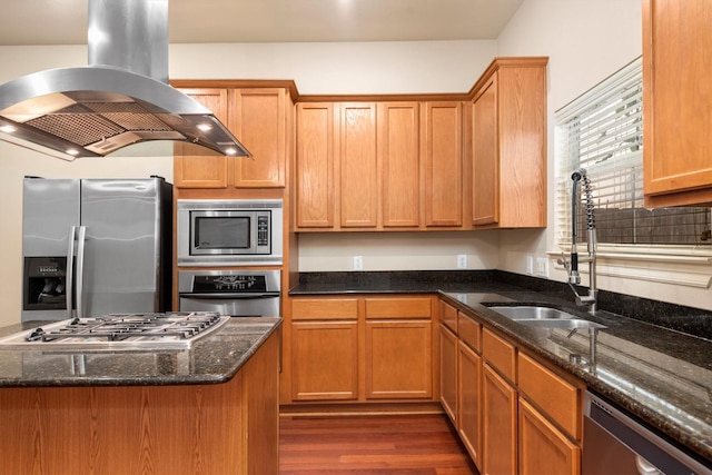 kitchen with sink, dark stone countertops, dark hardwood / wood-style flooring, island exhaust hood, and stainless steel appliances