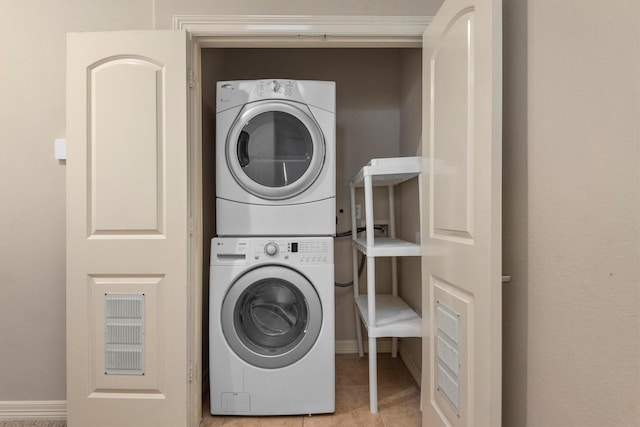 washroom with light tile patterned floors and stacked washer and dryer