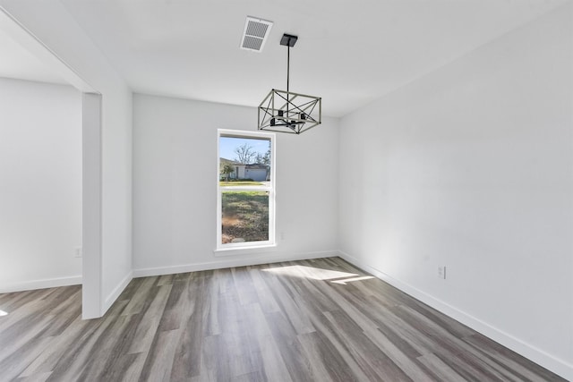 unfurnished dining area featuring light hardwood / wood-style floors and a chandelier