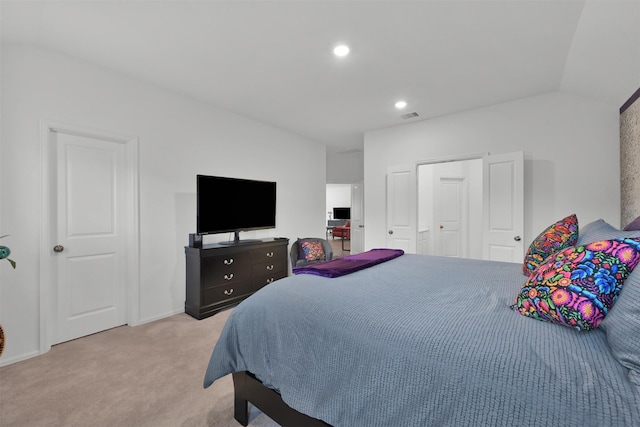 bedroom with light colored carpet and lofted ceiling