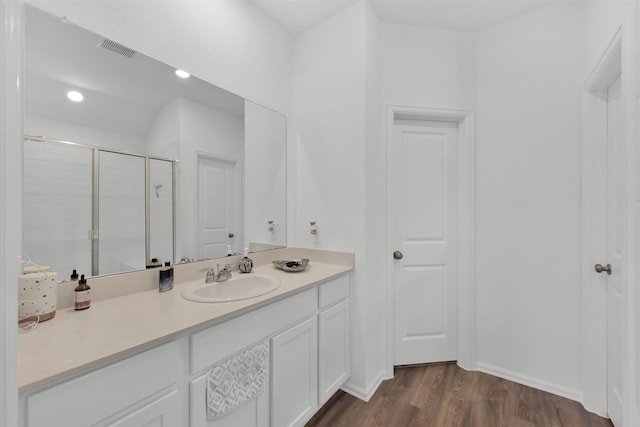 bathroom with hardwood / wood-style floors, vanity, and walk in shower