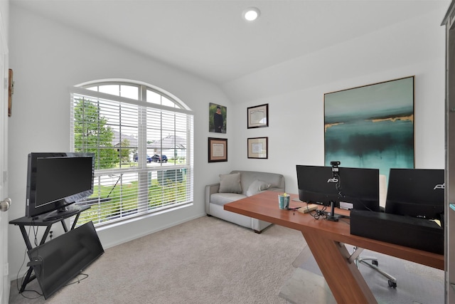 carpeted home office with lofted ceiling