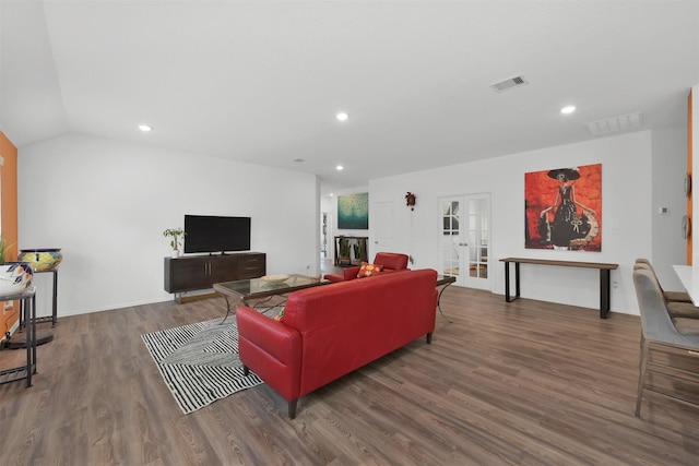 living room with dark hardwood / wood-style flooring, french doors, and vaulted ceiling