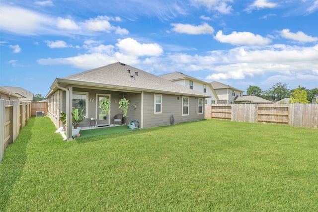 back of property featuring a lawn, central air condition unit, and a patio